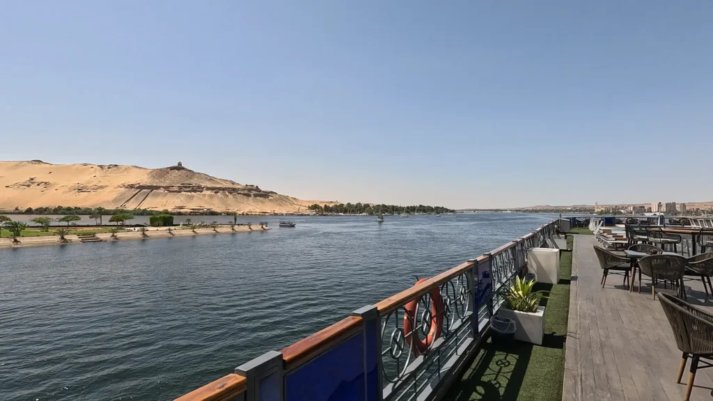 Navio de cruzeiro navegando pelo rio Nilo entre Luxor e Aswan, uma das melhores formas de explorar o Egito