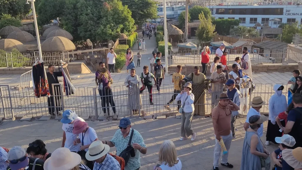 Ambulantes oferecendo lembranças a turistas na entrada de um templo egípcio.
