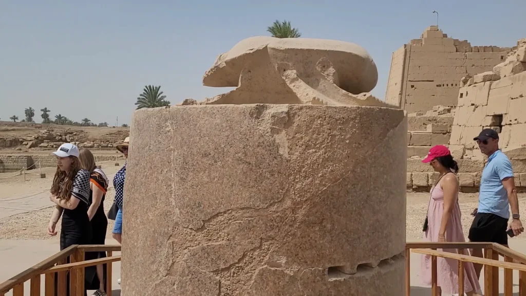 Escaravelho sagrado no templo de Karnak com visitantes ao redor
