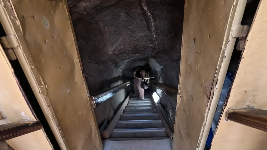 Visitantes acessando o interior da pirâmide de Gizé em corredor estreito