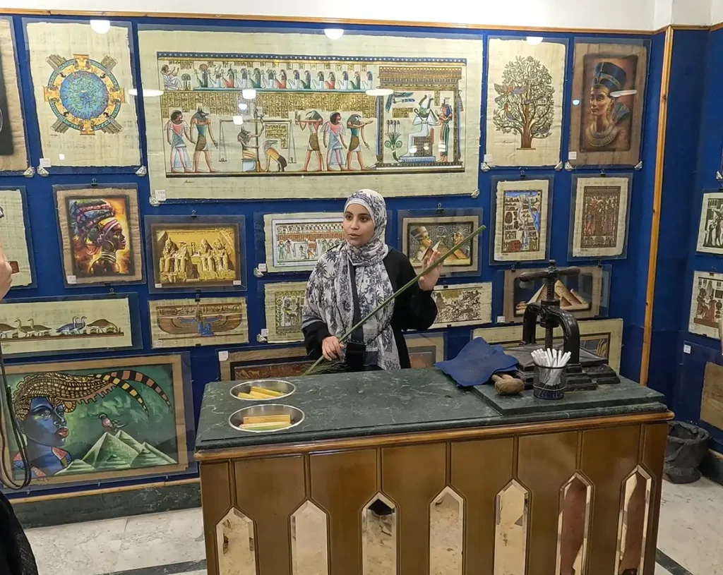Artesão egípcio demonstrando como se faz papiro em loja tradicional