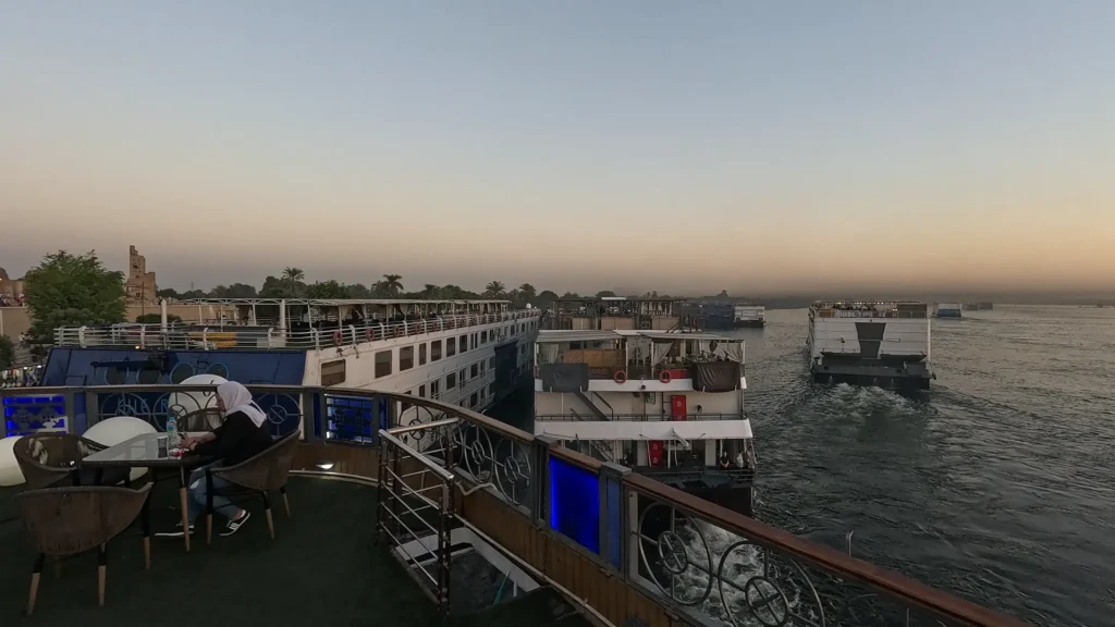 Navios de cruzeiro navegando pelo Nilo no fim da tarde, no Egito