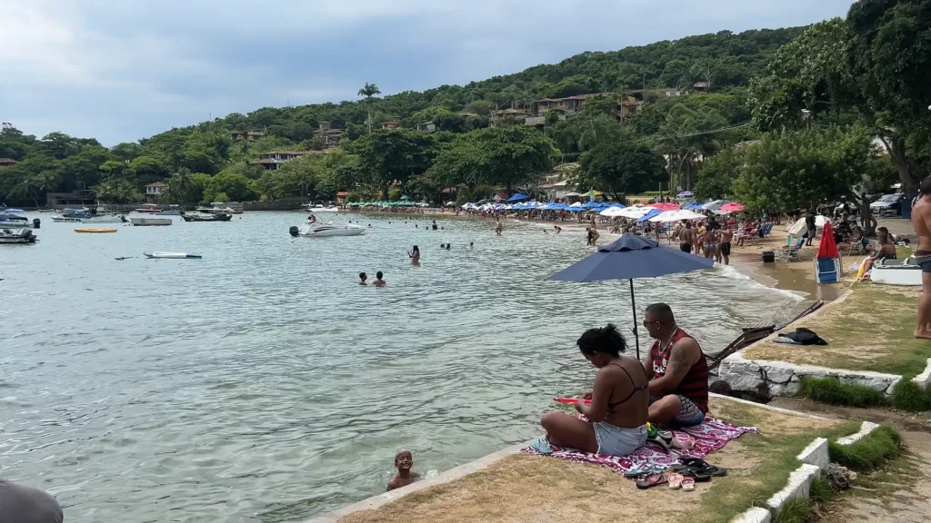 Vista da Praia dos ossos em Búzios com mar azul e faixa de areia pequena.