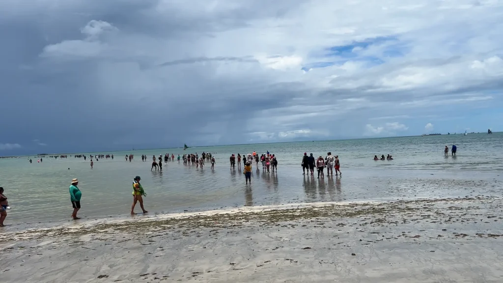 Turistas indo em direção ao caminho de moisés, entre as praias de Pajuçara e Ponta Verde.