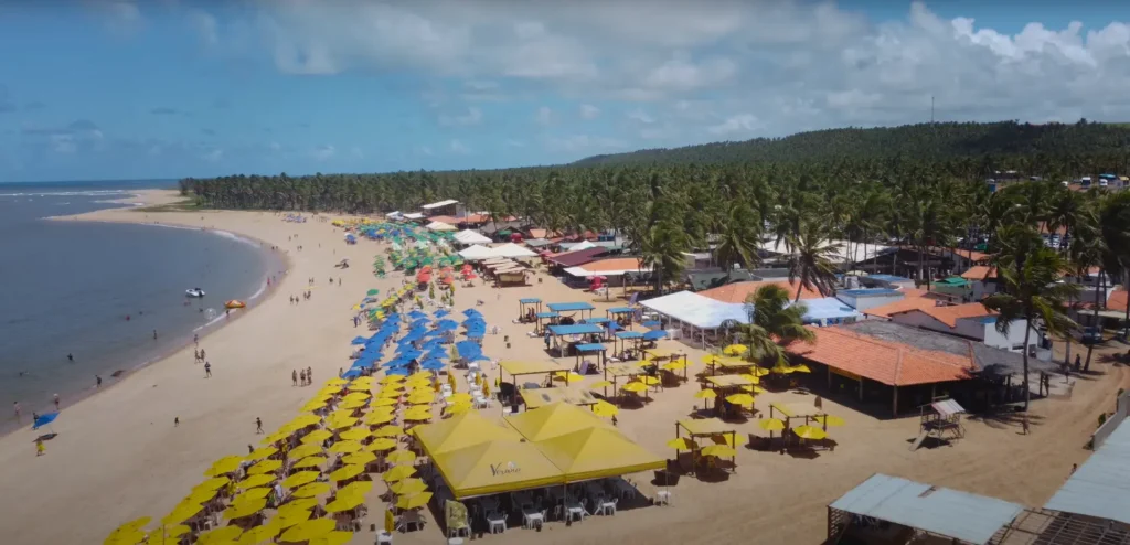 Praia do Gunga em Maceió, com coqueiros e mar azul.