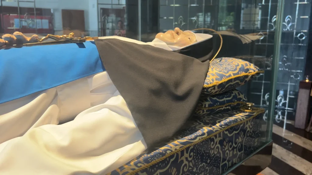 Corpo de Santa Dulce dos pobres e um esquife de vidro, exposto para visitação de devotos.