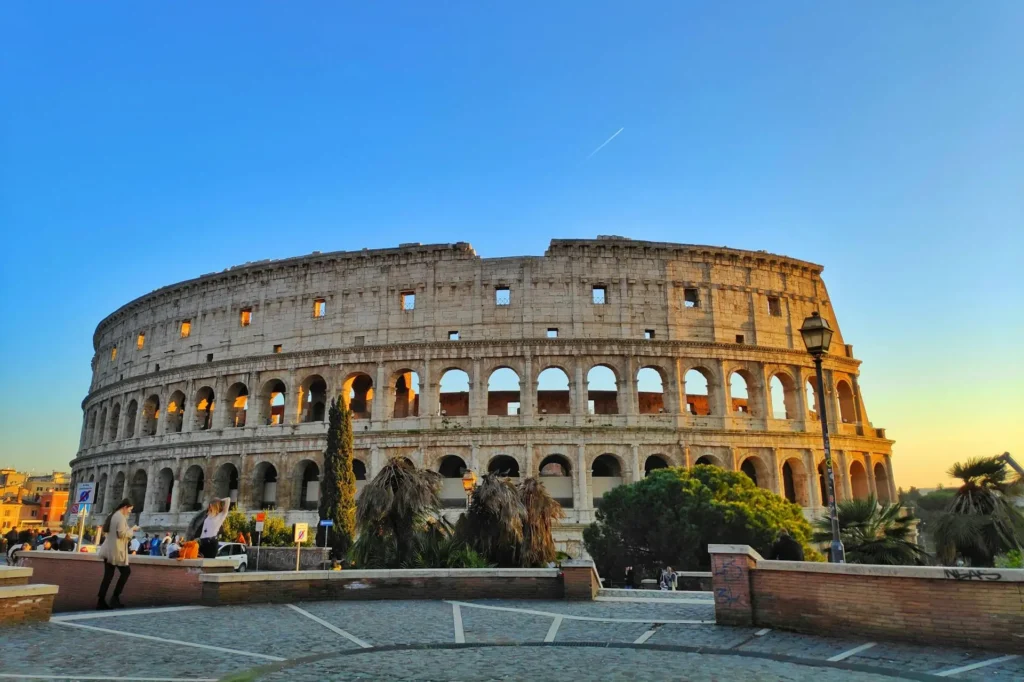 Coliseu de Roma com turistas em seu entorno.