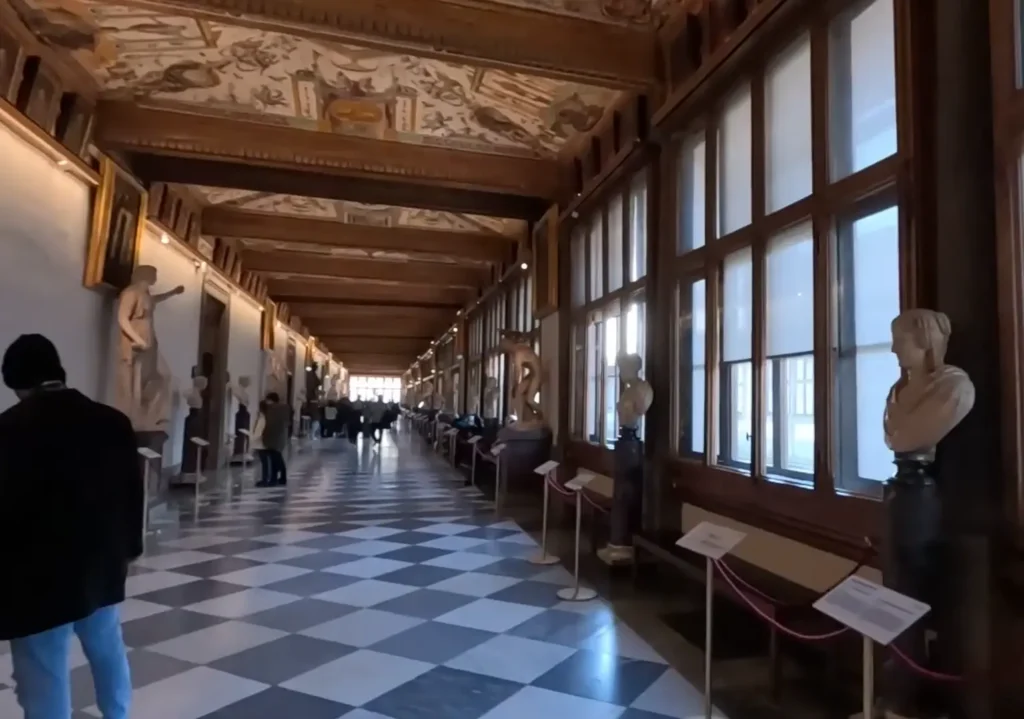 Corredor interno da Galeria Uffizi em Florença, com obras renascentistas expostas.
