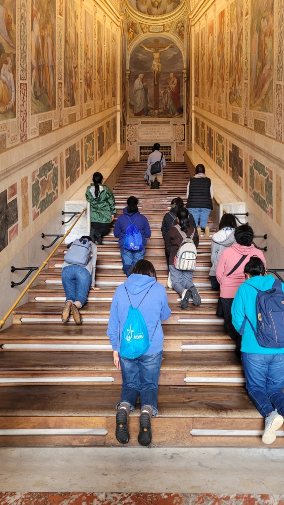 Peregrinos subindo de joelhos os 28 degraus que o próprio Jesus subiu para ser interrogado por Pôncio Pilatos, a escada foi trazida de Jerusalém para Roma por Santa Helena.