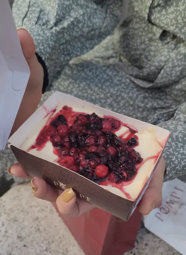 Mulher segurando um tiramissú, doce clássico de Roma.