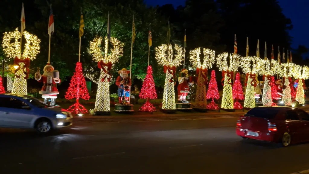 Rua decorada com iluminação natalina em Gramado durante a noite.